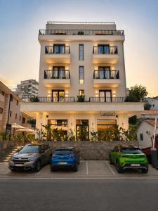 three cars parked in a parking lot in front of a building at Hotel Madeira in Budva