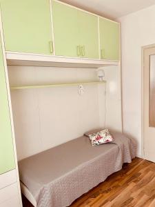 a bed in a room with green cabinets at A casa di Rita in Udine