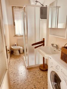 a bathroom with a sink and a washing machine at A casa di Rita in Udine +7 photos