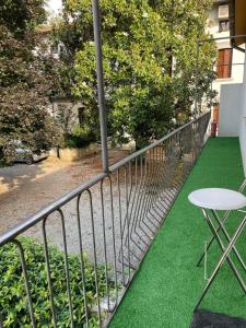 a balcony with green grass and a table and chair at A casa di Rita in Udine