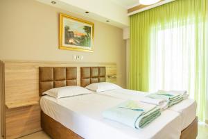 a bedroom with a large bed with towels on it at Sun Studios Pieria in Paralía Skotínis +229 photos