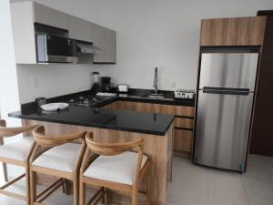 a kitchen with a black counter top and a refrigerator at Suites Santa Isabella in Ajijic