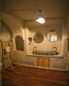 a bathroom with a tub and two mirrors on the wall at Potamia Cave Suites in Ortahisar +162 photos
