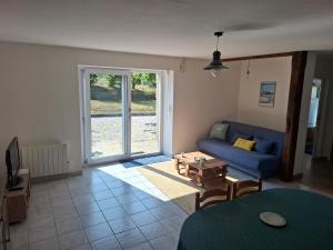 a living room with a blue couch and a table at Logis du fresne in Saint-Lormel