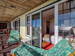 a room with a balcony with a bed and a bedroom at Eindelik in Simonʼs Town