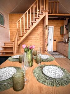 a wooden table with plates and flowers on it at Carpathian Barns in Abranka