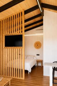 a bedroom with a bed and a flat screen tv at Camping Preguntoiro in Sanxenxo +48 photos