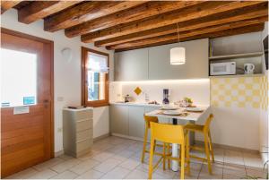 a kitchen with yellow chairs and a table in a room at TIFFANY GOLD in Burano