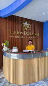 a man sitting at a bar in a hotel at Hotel Lirios Dorados in Iquitos