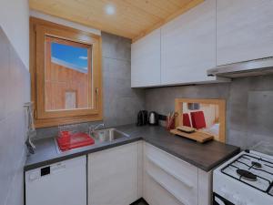 a kitchen with white cabinets and a sink at Le Génépi in La Plagne Tarentaise