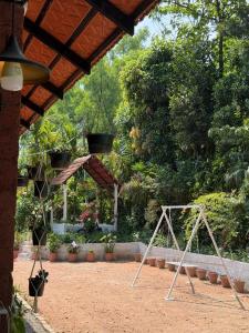 a swing set in a garden with plants at Koppalu Heritage in Vastāra