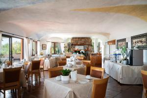 ein Restaurant mit Tischen, Stühlen und einem Kamin in der Unterkunft Hotel Valdiola in Porto Cervo