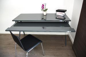 a black desk with a black chair and a plant at Hollywood Guesthouse in Los Angeles