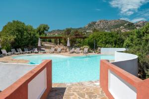 Ein Swimmingpool in einem Ferienort mit Bergen im Hintergrund in der Unterkunft Hotel Valdiola in Porto Cervo