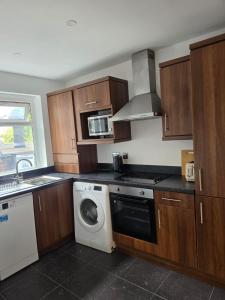 a kitchen with a washing machine and a washer at Kingfield Boutique Hotel in Sheffield