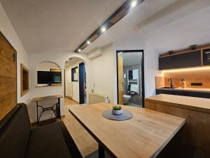 a living room with a table and a kitchen at Enzian Apartments in Kartitsch