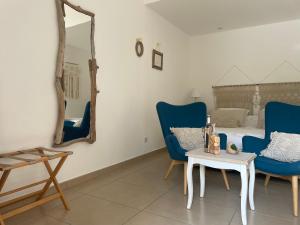 a room with two blue chairs and a table and a bed at La maison de la Cigale in Forcalqueiret +66 photos