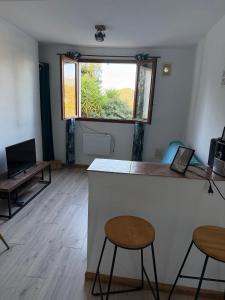Ein Zimmer mit einer Bar mit zwei Barhockern und einem Fenster in der Unterkunft U refuggiu in Porticcio
