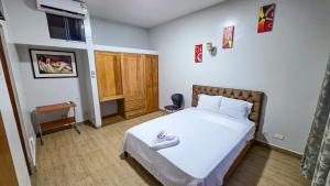 a bedroom with a bed and a desk in it at Hotel Lirios Dorados in Iquitos