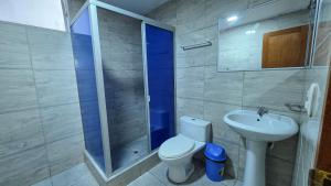 a bathroom with a shower and a toilet and a sink at Hotel Lirios Dorados in Iquitos +24 photos