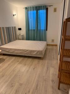 ein Schlafzimmer mit einem Bett und einem Holzboden in der Unterkunft U refuggiu in Porticcio