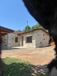 a stone house with a driveway in front of it at Villa Ndoj Bukmire in Rrëshen +13 photos