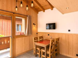 a dining room with a wooden table and chairs at L'edelweiss in La Plagne Tarentaise