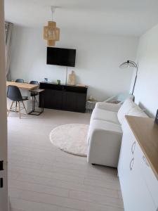 a white living room with a couch and a table at L'évasion Marine in Camiers