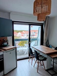 a kitchen with a table and chairs and a balcony at L'évasion Marine in Camiers +17 photos