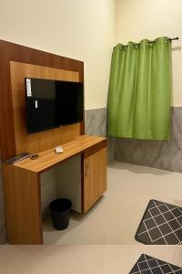 a room with a tv on a desk with a green curtain at Hotel Grand RK Residency Rukmani Vihaar - #PremManir #Chaar Dham #Parking #Affordable Stay in Vrindāvan