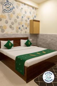 a bedroom with a bed with a green blanket at Hotel Grand RK Residency Rukmani Vihaar - #PremManir #Chaar Dham #Parking #Affordable Stay in Vrindāvan