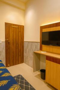 a room with a bed and a flat screen tv at Hotel Grand RK Residency Rukmani Vihaar - #PremManir #Chaar Dham #Parking #Affordable Stay in Vrindāvan