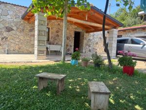 a house with two wooden benches in a yard at Villa Ndoj Bukmire in Rrëshen