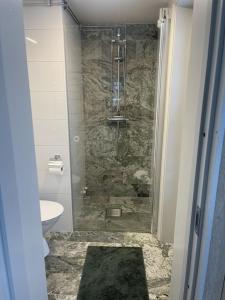 a bathroom with a shower with a sink and a toilet at Järvsöbranten 7 med 10 sovplatser och vedeldad badtunna, 400 m från lift in Järvsö +30 photos