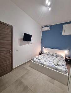 a bedroom with a bed and a tv on the wall at Holiday Home B&M Apt2 -Apt3 in Pozzallo