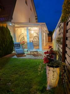 a gazebo with two chairs in a yard at night at Reda in Rowy +5 photos