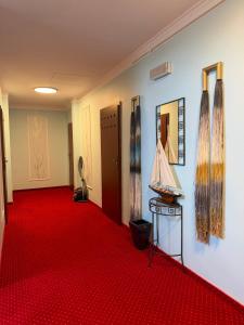 a hallway with a red carpet and a room with doors at Reda in Rowy