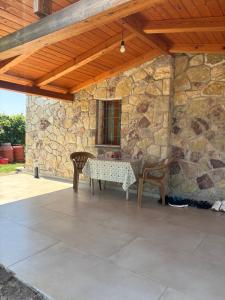 a patio with a table and chairs under a stone wall at Villa Ndoj Bukmire in Rrëshen