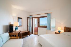 ein Schlafzimmer mit zwei Betten, einem Schreibtisch und einem Fenster in der Unterkunft Hotel Valdiola in Porto Cervo + 63 Fotos