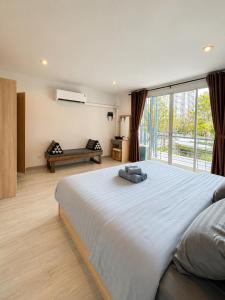 a bedroom with a large bed and a large window at Sena living Tiwanon Rd in Ban Bang Kradi (1)