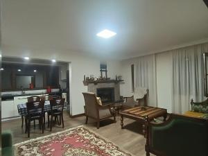 a living room with a fireplace and a dining room at Deniz house apart in Güzelce