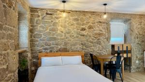 a bedroom with a bed and a stone wall at Catapeixe Holiday Apartments in Redondela +83 photos