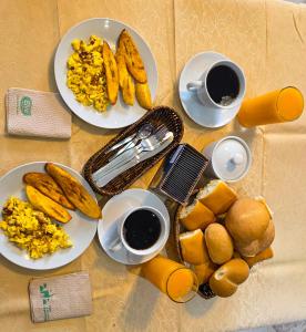 a table with plates of food and two cups of coffee at Hotel Lirios Dorados in Iquitos