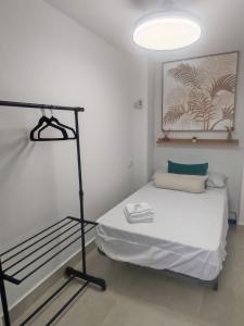 a small room with a bed and a light at Ancha 4 en pleno centro in Sanlúcar de Barrameda