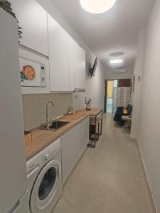 a kitchen with a sink and a washing machine at Ancha 4 en pleno centro in Sanlúcar de Barrameda