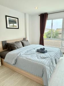 a bedroom with a large bed and a window at Sena living Tiwanon Rd in Ban Bang Kradi (1)