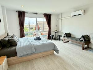 a bedroom with a bed and a desk and a window at Sena living Tiwanon Rd in Ban Bang Kradi (1)