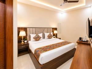 a hotel room with a bed and a television at Hotel RK Plaza - Rukmani vihaar - #Parking #Best Rated Area #Fully Ac #Prem Mandir #Chaar Dhaam in Vrindāvan