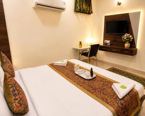 a hotel room with a bed with a table and a television at Hotel RK Plaza - Rukmani vihaar - #Parking #Best Rated Area #Fully Ac #Prem Mandir #Chaar Dhaam in Vrindāvan