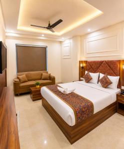 a bedroom with a large bed and a couch at Hotel RK Plaza - Rukmani vihaar - #Parking #Best Rated Area #Fully Ac #Prem Mandir #Chaar Dhaam in Vrindāvan